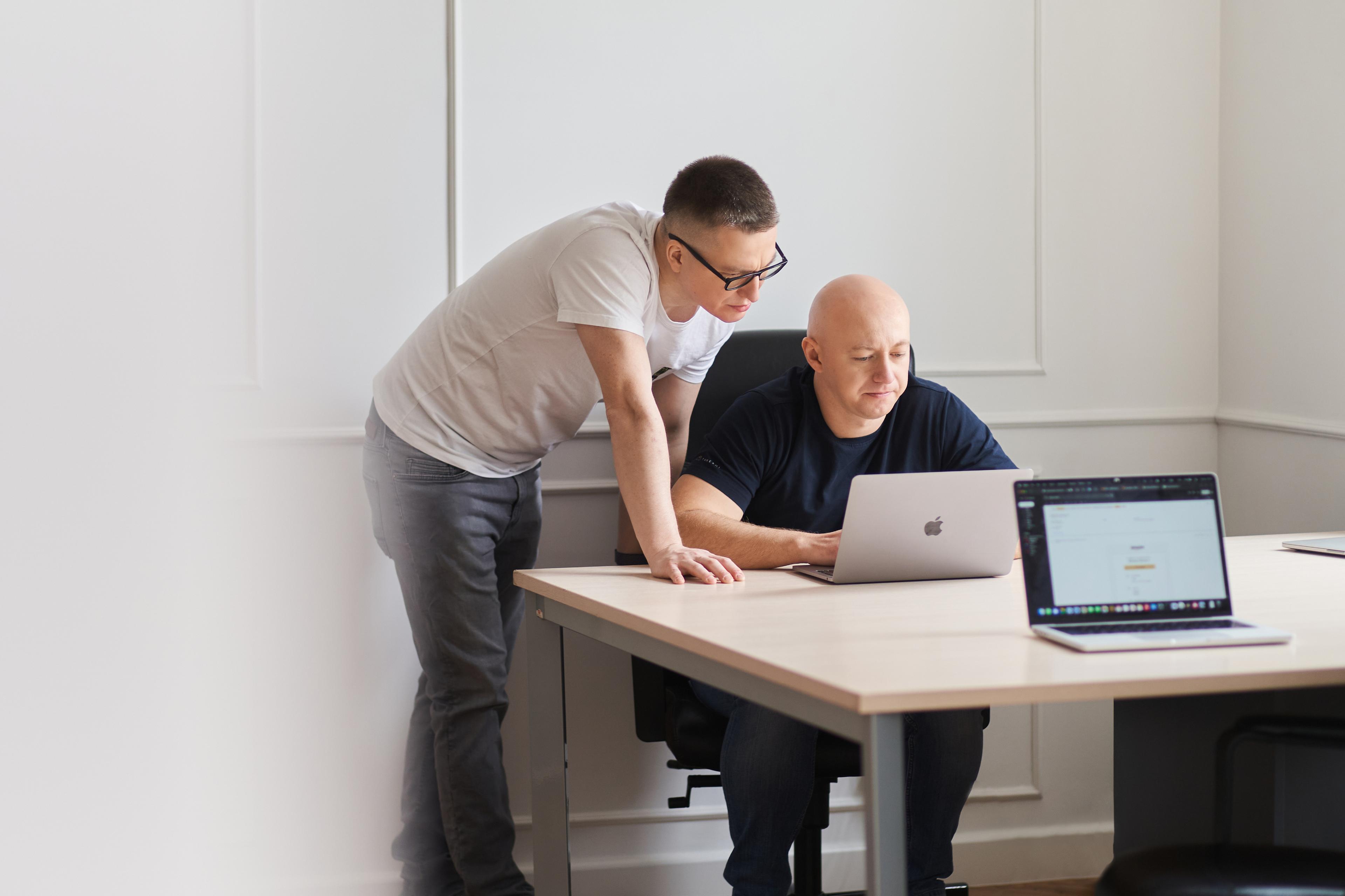 Photo of two men in front of the computer